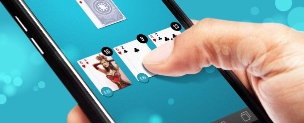 Close-up of a hand playing online blackjack on a smartphone screen, featuring a vibrant blue background. The game interface shows a player's hand with cards, including the Queen of Hearts.