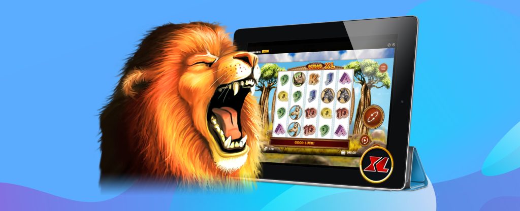 A 3D-animated lion is seen from the shoulders up to the left of the image roaring in front of an iPad, showing a screenshot of the SlotsLV slots game, Savanna King XL. The screen preview shows a 5-reel slot game with an animated background of the savanna, with tall trees with green leaves either side of the reels. Behind is a blue abstract background.