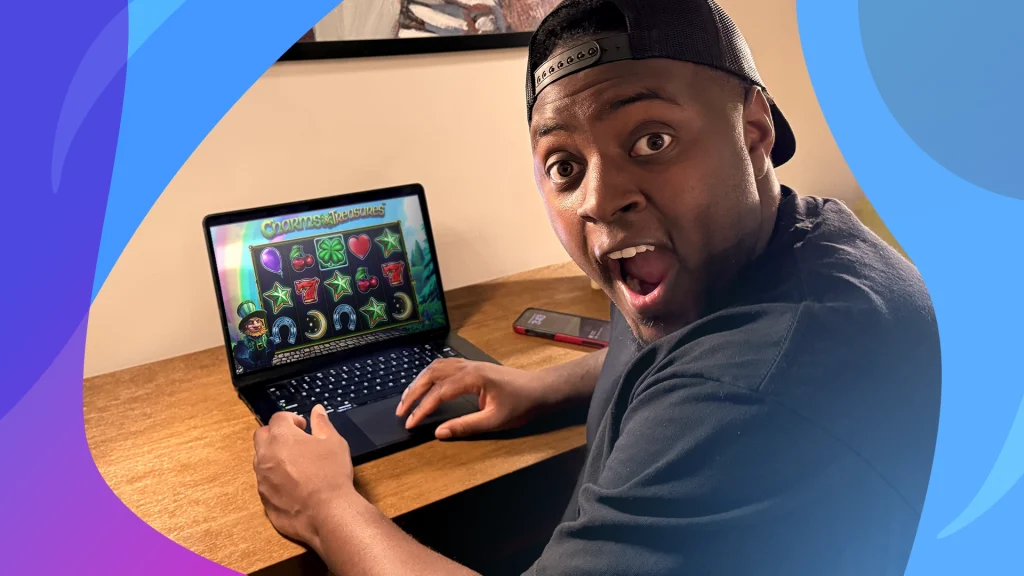 Influencer Jackpot Jay Vegas looks surprised while playing Charms & Treasures on his laptop.