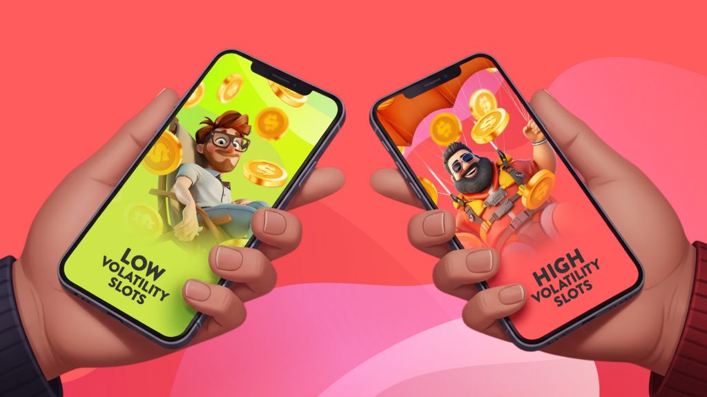 Two hands hold low volatility and high volatility slots on mobile phones in a pink image.